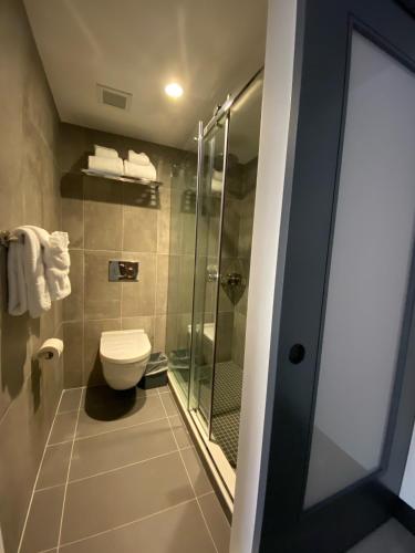 a bathroom with a toilet and a glass shower at Wingate by Wyndham New York Midtown South/5th Ave in New York