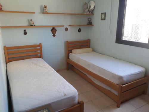 1 Schlafzimmer mit 2 Betten und einem Fenster in der Unterkunft Apartamento para 6 pessoas a 10m da praia in Praia Grande