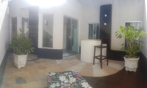a lobby with two potted plants in a building at L'acqua Motel Express in Ponta Grossa