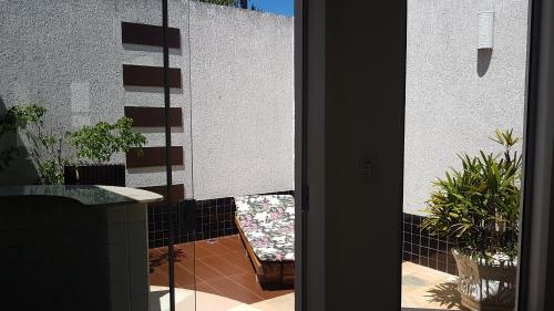an open door to a balcony with a chair and plants at L'acqua Motel Express in Ponta Grossa