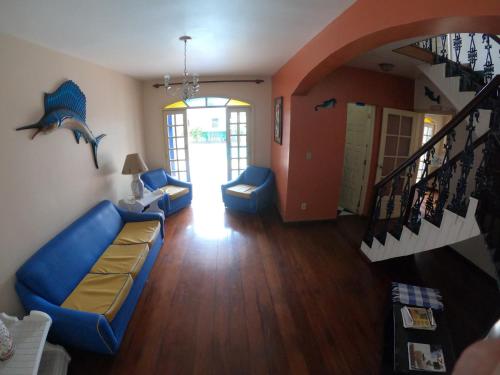 a living room with blue chairs and a staircase at Pousada Portal do Mar in Cabo Frio