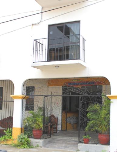a white building with a balcony and plants at Hotel Arrecife Huatulco Plus in Santa Cruz Huatulco