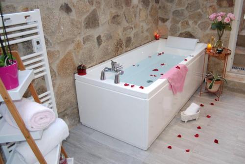 uma banheira branca num quarto com uma parede de pedra em A LA BELLE EPOQUE em Épernay