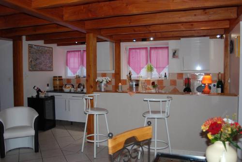 une cuisine avec des placards blancs et des fenêtres roses dans l'établissement A LA BELLE EPOQUE, à Épernay