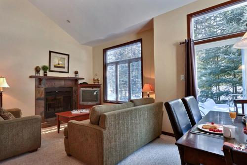 a living room with a couch and a fireplace at Aiglon by Rendez-Vous Mont-Tremblant in Mont-Tremblant