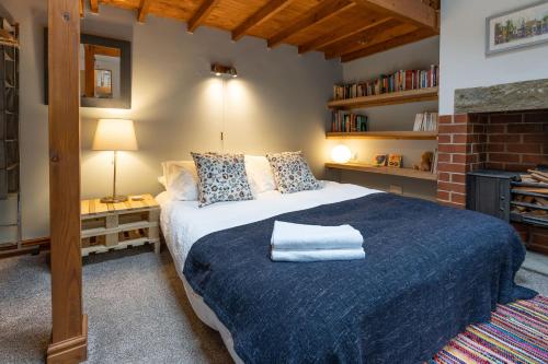 a bedroom with a large bed with a blue blanket at Old Coach House - "Loved staying here" in Sheffield