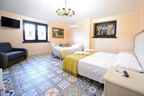 a hotel room with two beds and a chair at Domus Ansantica in Villamaina
