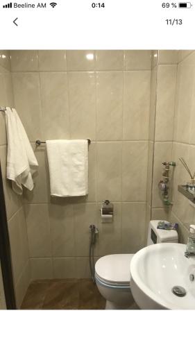 a bathroom with a white toilet and a sink at Уютная квартира около станции метро in Yerevan