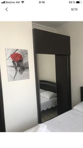 a mirror in a bedroom next to a bed at Уютная квартира около станции метро in Yerevan