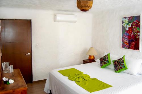 a bedroom with a bed with a green blanket on it at Petit Hotel Pilitas in Puerto Vallarta