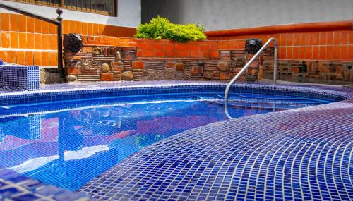 a swimming pool with a hose attached to a building at Petit Hotel Pilitas in Puerto Vallarta