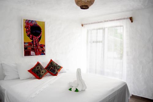 a bedroom with a bed with white sheets and a window at Petit Hotel Pilitas in Puerto Vallarta