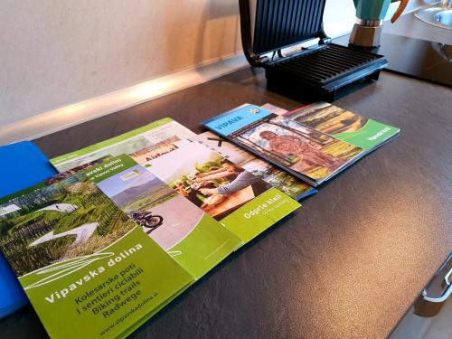 two brochures sitting on top of a table at Restaurant & Apartments Getaway Pri Kobalu in Vipava