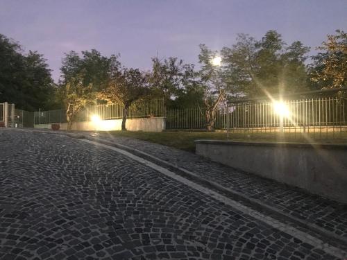 a cobblestone street at night with lights on a fence at B&B Oasi Vetoio in LʼAquila