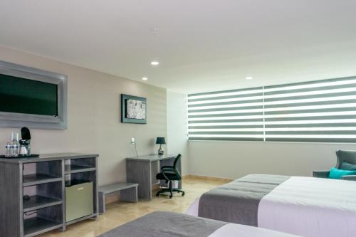 a hotel room with two beds and a flat screen tv at Hotel 5 Inn Plus in León