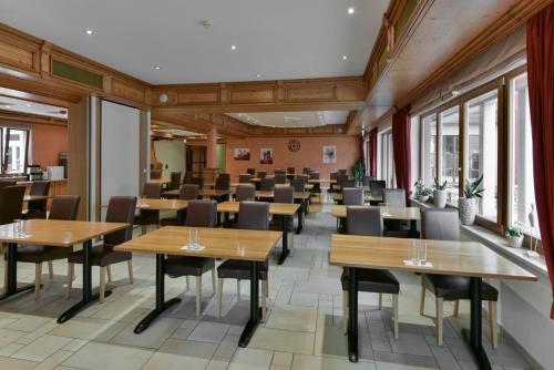 a dining room with tables and chairs and windows at Hotel Belle Vue in Vianden