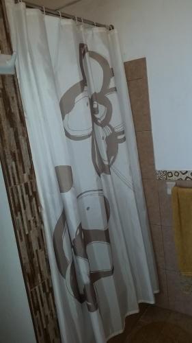 a bathroom with a shower curtain with a toilet at Maria Jose Bungalows in Zorritos