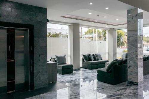 a lobby with two chairs and a fireplace at Hotel 5 Inn Plus in León