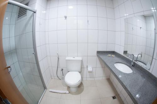 a bathroom with a toilet and a sink and a shower at Getúllio Hotel in Cuiabá