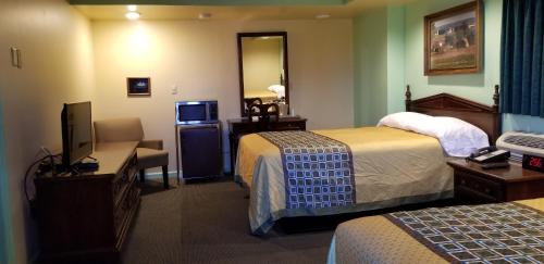 a hotel room with two beds and a television at Classic Inn Lancaster in Lancaster