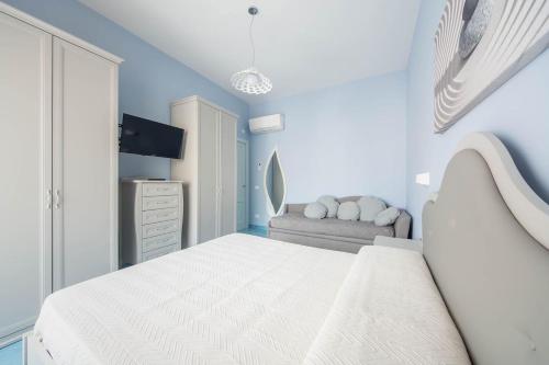 a white bedroom with a bed and a couch at La Casa del Poeta - Appartamento Positano in Maiori