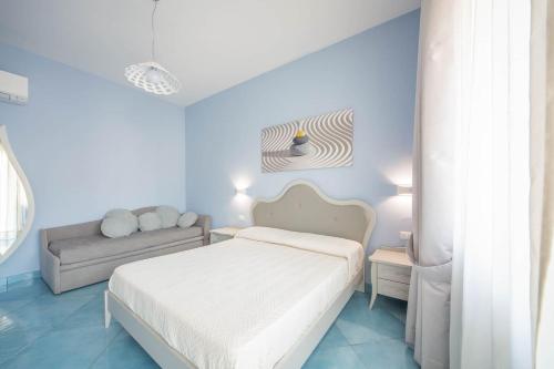 ein Schlafzimmer mit einem weißen Bett und einem Sofa in der Unterkunft La Casa del Poeta - Appartamento Positano in Maiori