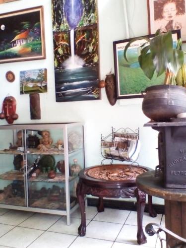 une chambre avec une table et des photos sur le mur dans l'établissement Hostal del Este Santa Fe, à San José