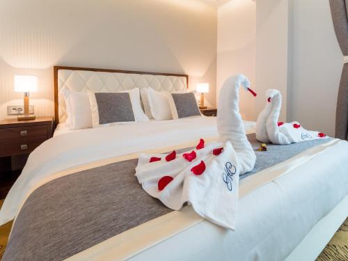 two swans towels on a bed in a hotel room at Hotel Buket Zlatibor in Zlatibor