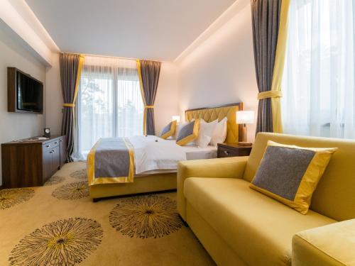 a hotel room with a bed and a couch at Hotel Buket Zlatibor in Zlatibor