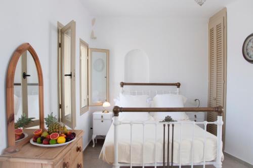 a bedroom with a bed and a bowl of fruit on a table at Lithia Villas in Chora Folegandros