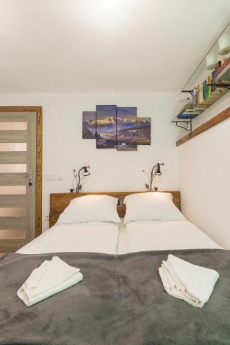 two beds in a bedroom with white walls at TatraApart Rent E-Bike in Kościelisko