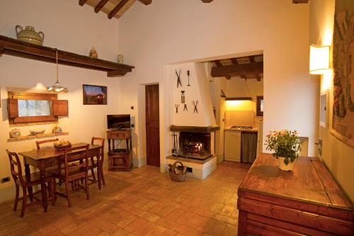 Una sala de estar con una mesa y una chimenea. en Podere Pietreta, en Radicofani