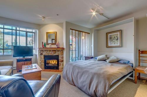 a bedroom with a bed and a fireplace at Town Plaza Suites by Golden Dreams in Whistler