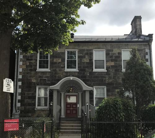 an old brick house with a red door at Pring Guesthouse in Hamilton