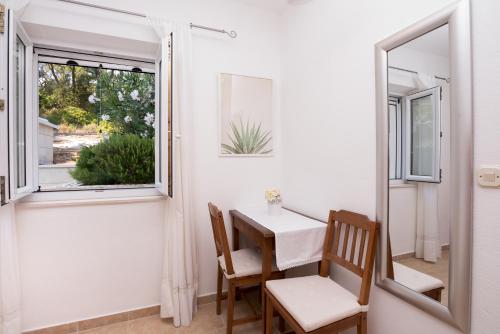 a dining room with a table and chairs and a window at Villa Katja in Sumartin