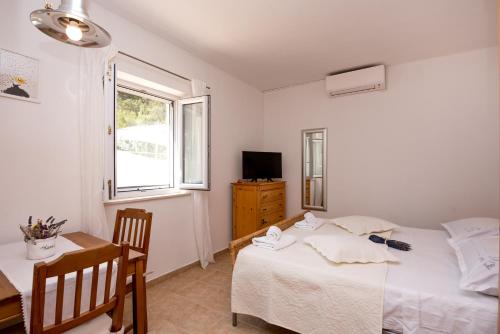 a bedroom with a bed and a desk and a window at Villa Katja in Sumartin