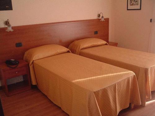a bedroom with two beds and a table with a bedskirts at Soggiorno Boccuti in Montella