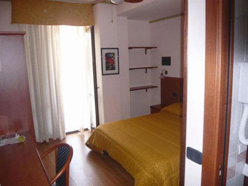 a bedroom with a yellow bed and a window at Soggiorno Boccuti in Montella