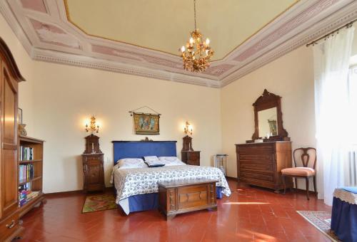 a bedroom with a bed and a chandelier at Villa Buonaparte in San Miniato
