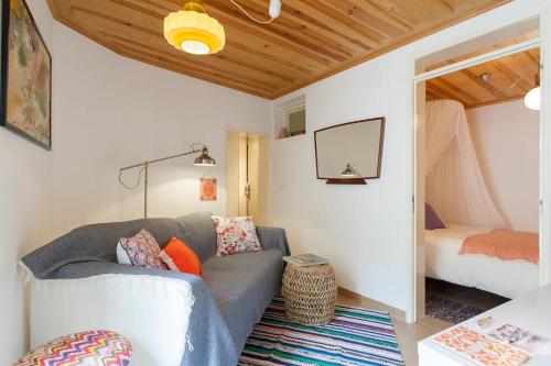 a living room with a couch and a bed at Alfama Charming Apartment, By TimeCooler in Lisbon