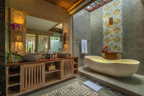 a bathroom with two sinks and a bath tub at Bliss Ubud Luxury Villa in Ubud