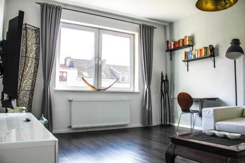 salon z dużym oknem i kanapą w obiekcie EXKLUSIVE 2 Zimmer Wohnung mit Balkon in Top Lage! w Bremie