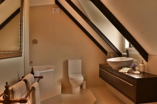 a bathroom with a sink and a toilet in a attic at Country Homestead at Black Sheep Farm in Waipu
