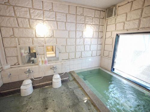 a bathroom with a swimming pool with a large window at Hotel Route-Inn Tajimi Inter in Tajimi