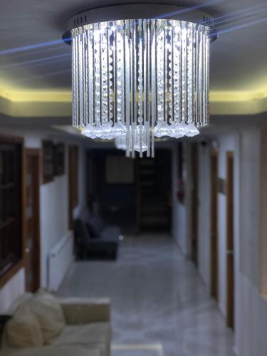 a chandelier hanging from the ceiling in a living room at Residencial Victoria Said in Linares