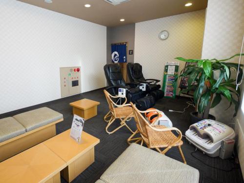 a living room with a couch and chairs in a room at Hotel Route-Inn Toyokawa Inter in Toyokawa