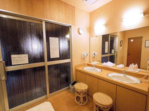 a bathroom with two sinks and a large mirror at Hotel Route-Inn Toyokawa Inter in Toyokawa