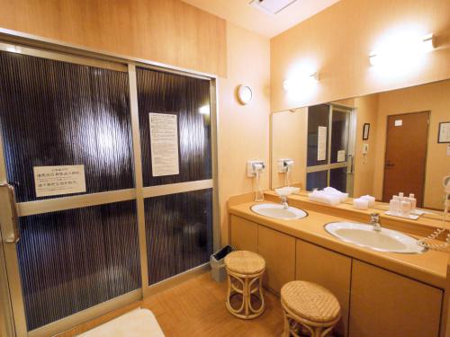 un bagno con due lavandini e un grande specchio di Hotel Route-Inn Toyokawa Inter a Toyokawa