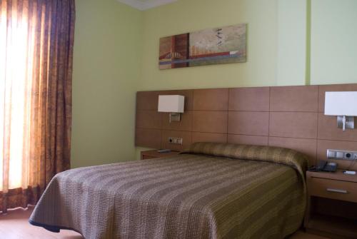 een slaapkamer met een bed en een raam bij Hotel 4C Puerta Europa in Madrid