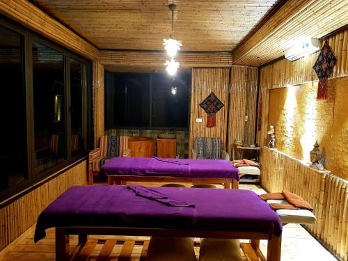 a row of purple beds in a wooden room at Sapa Clay House - Mountain Retreat in Sapa